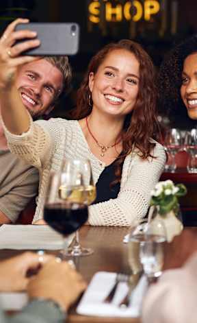 A group of people are taking a selfie at a wine bar.