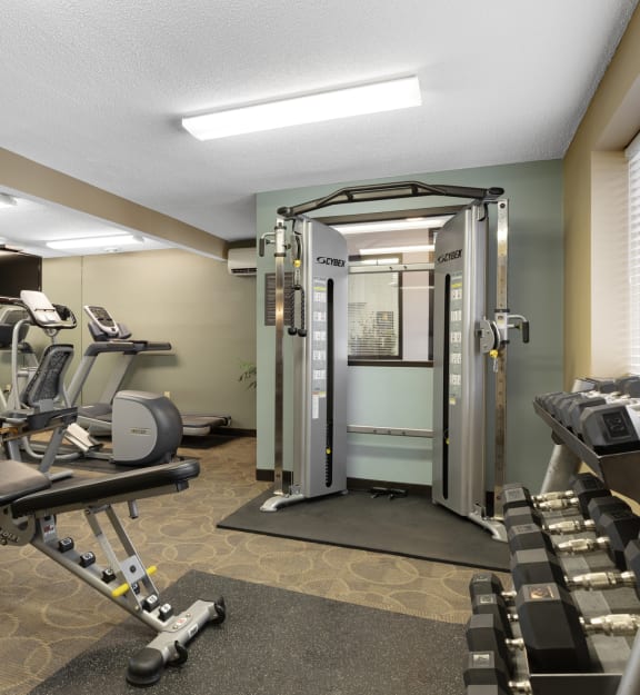a gym with exercise equipment and mirrors in a treatment room at Valley Pond, Apple Valley, Minnesota