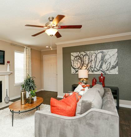 a living room with a fireplace and a ceiling fan