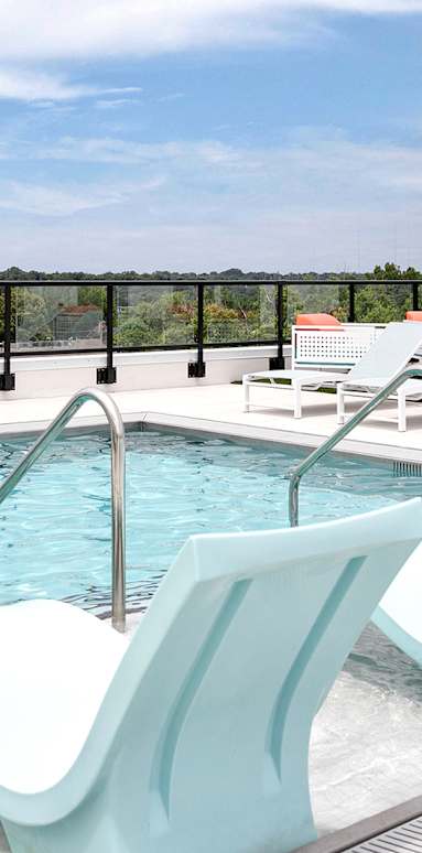 A pool with a white and blue lounge chair.