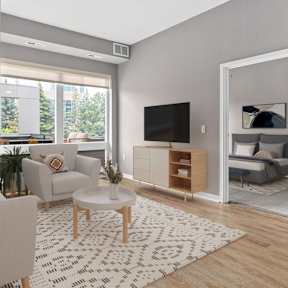 A living room with a white couch, a coffee table, and a television.