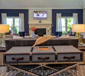 A living room with a black couch and a fireplace.