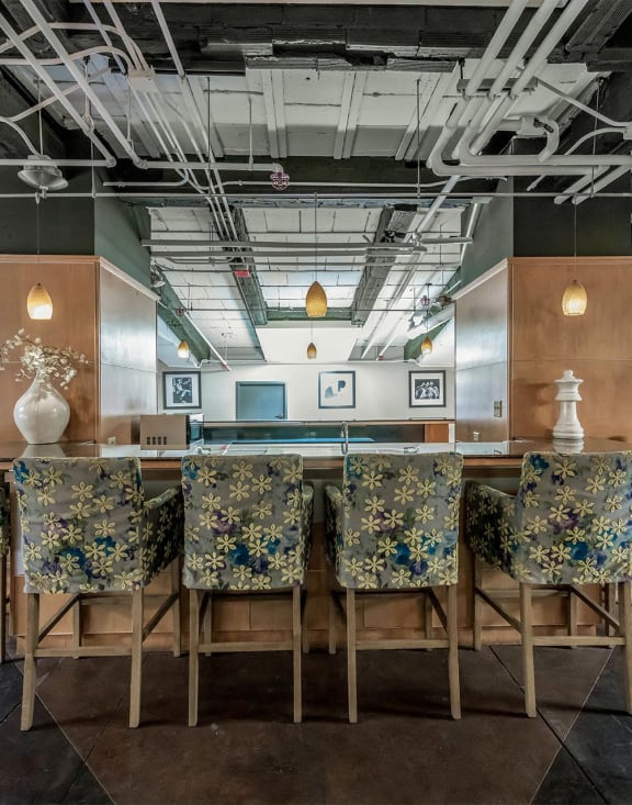 a long bar with chairs and a table in a lobby