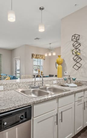 a kitchen with white cabinets and granite counter tops and a sink