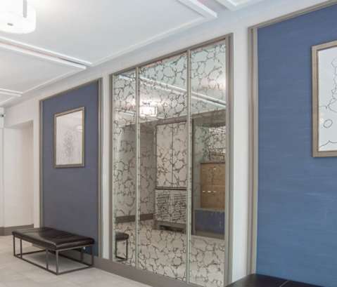 the lobby of a building with benches and a mirror