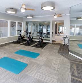 A gym with a variety of equipment including treadmills, weights, and exercise machines.