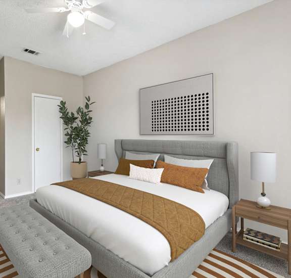 A bedroom with a large bed and a ceiling fan.