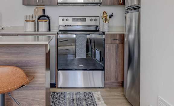 A modern kitchen with a stainless steel refrigerator and oven.