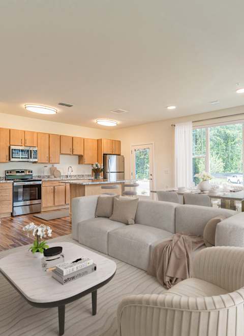 A modern living room with a large couch, a coffee table, and a flat-screen TV.