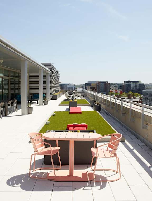 A patio with a table and chairs overlooks a city street at Artline Apartments, Washington, DC, 20024