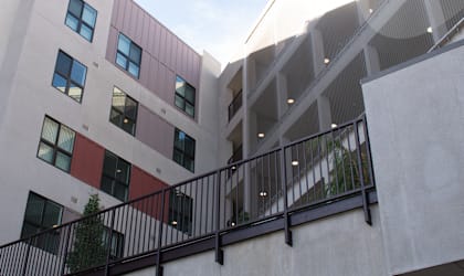 A building with a balcony and a tree.