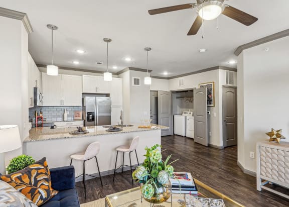a living room and kitchen with a ceiling fan