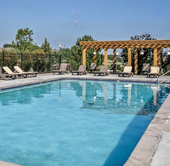 A patio with a fire pit and a pergola.