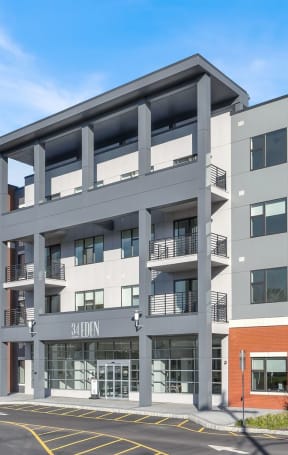 a rendering of a four story apartment building with people walking on the sidewalk in front of it