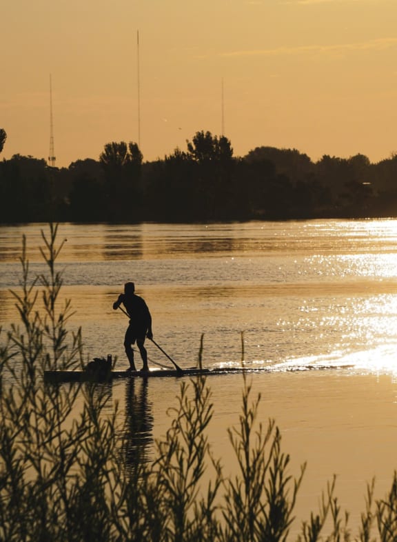 Man on Paddleboard During Sunset