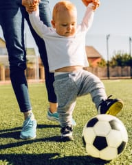 Young Child Kicking Soccer Ball