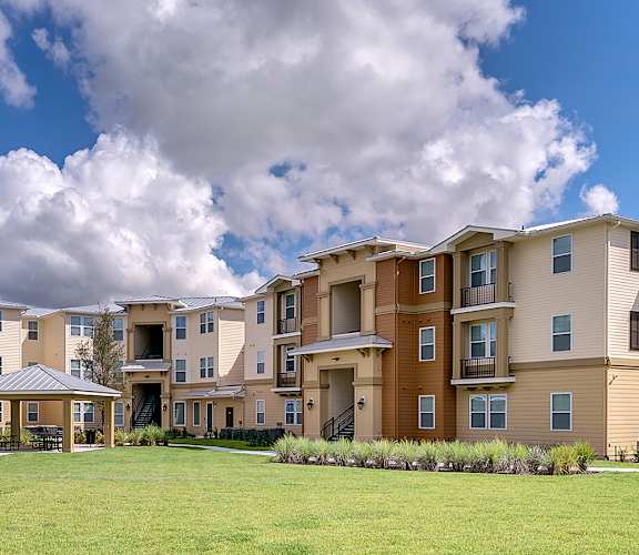 a large grassy area in front of an apartment complex