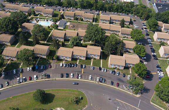 A view of a roundabout with cars and apartment buildings.