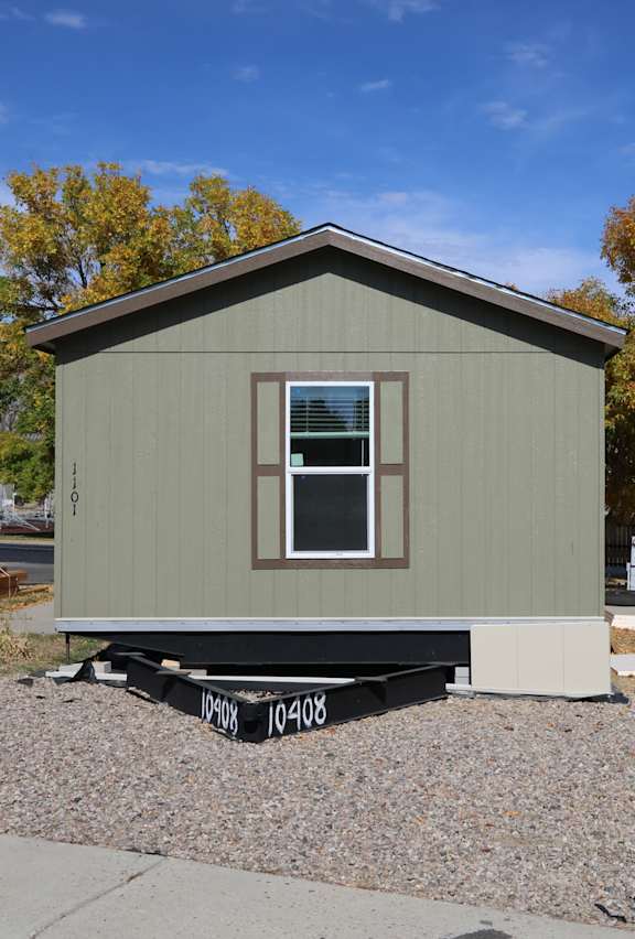 a tiny house on a trailer parked in front of a driveway at Pioneer Park, Green River, Wyoming
