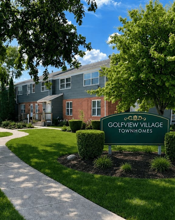 A sign that says Golfview Village Townhomes in front of a building.