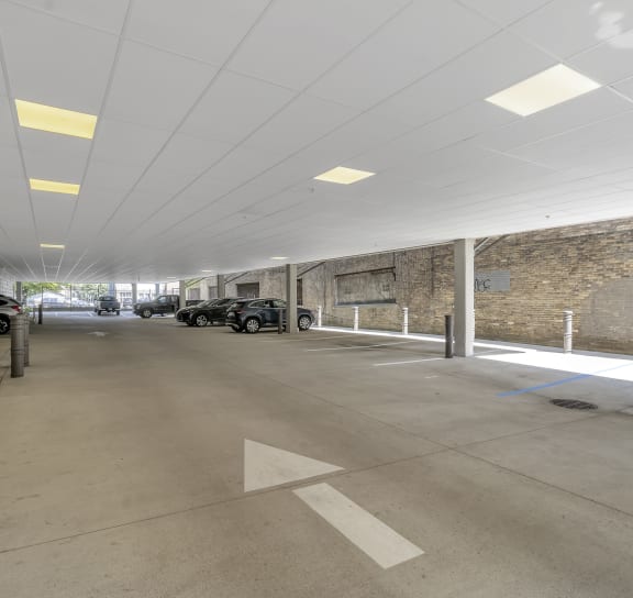 a parking garage with cars and a brick wall  at Nineteen North, Buffalo, 14202