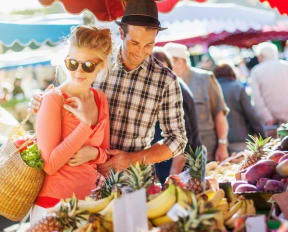 Trendy Young Couple Perusing Local Farmer's Market Produce