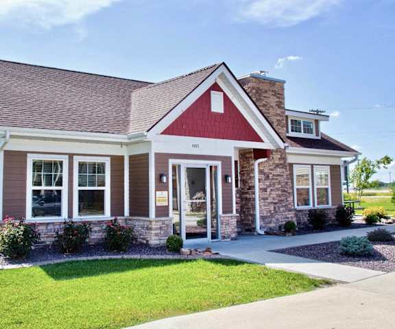 the front of a house with a lawn and a driveway