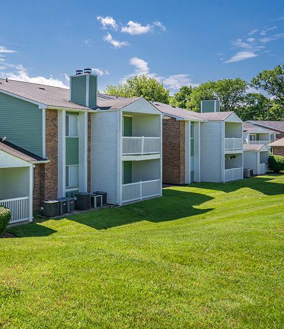 A row of houses with green roofs and white walls.