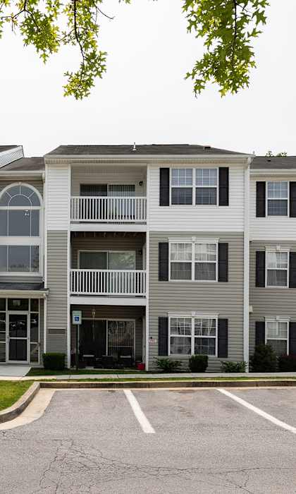 Apartment building with a parking lot in front.