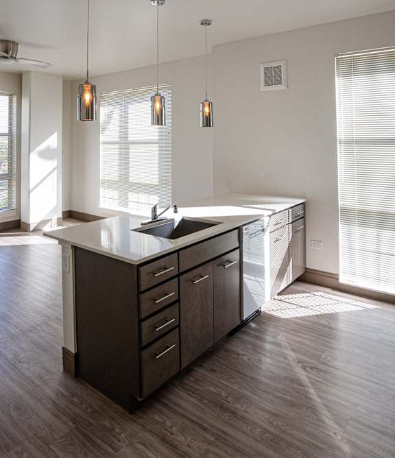An interior of a kitchen with an island and hardwood floors