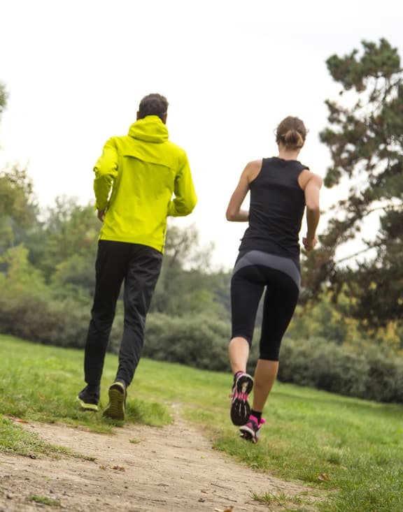 Two people running on a trail
