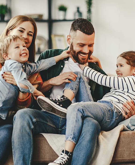 a family sitting on a couch with two children  at Parks on the Green, Temple