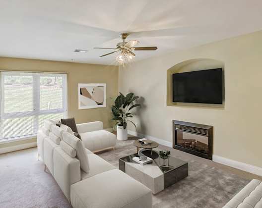 A living room with a fireplace and a flat screen TV mounted on the wall.