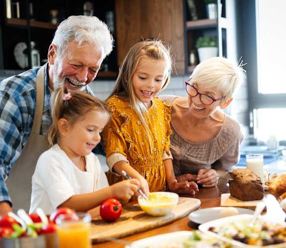 a family is gathered around a kitchen table eating food