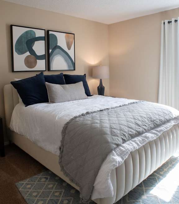 A made bed with art above it on the wall