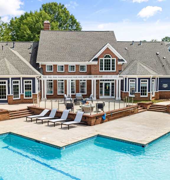 A large house with a pool in front.