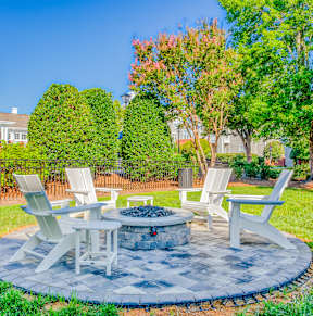 A white table and chairs are set up in a backyard.