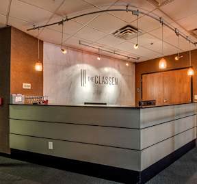 The interior of a reception area with a counter and a wall with a sign that reads "The Classen".