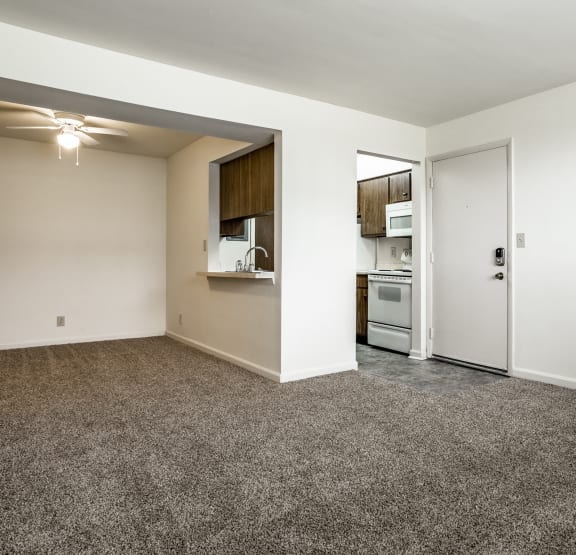 an empty living room with wood flooring and a white door at Bay Pointe Apartments in Lafayette, IN