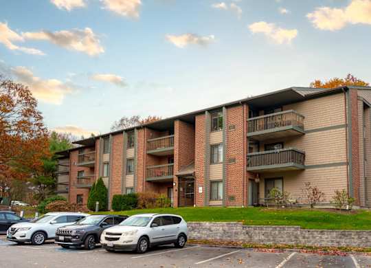 an apartment building with cars parked in a parking lot