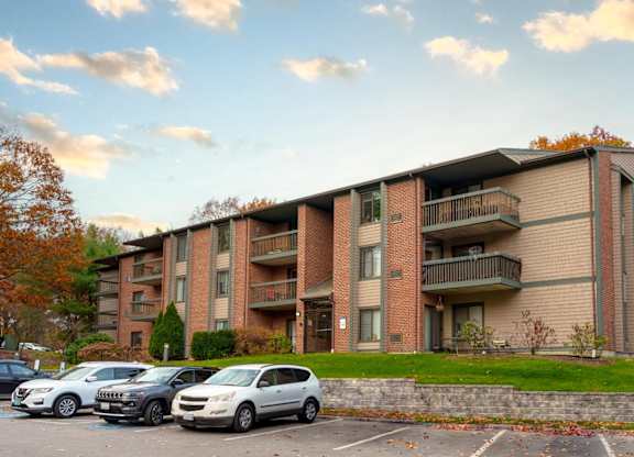 an apartment building with cars parked in a parking lot