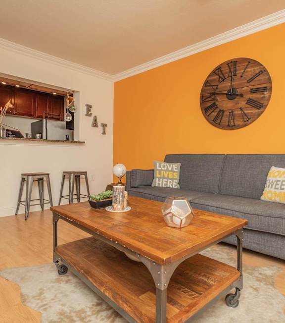 A living room with a grey couch and a wooden coffee table. at The Cove at State Street Apartments, Baton Rouge, LA, 70802