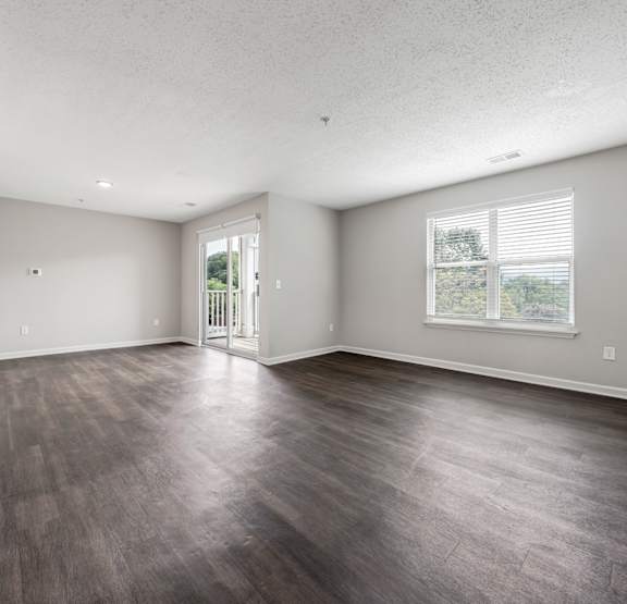a spacious living room with plank floors and a kitchen in the background at Sunscape Apartments, Roanoke, VA, 24018