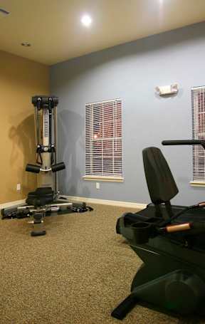A pool table is in the middle of a room with a TV and a chair.