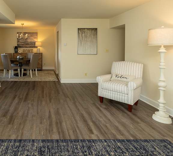 A living room with a chair and a lamp at The Brittany Apartments, Maryland