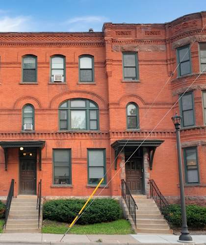 a red brick building with a black car parked in front of it