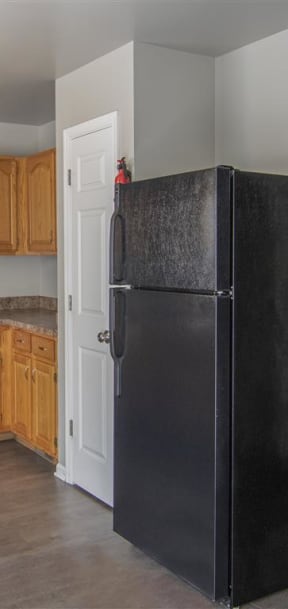 a kitchen with white cabinets and a black stove and refrigerator