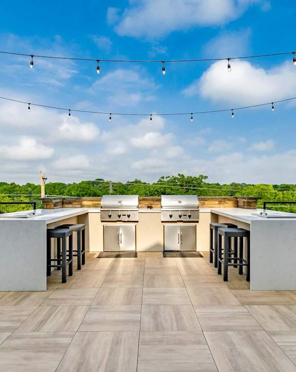 an outdoor kitchen with stainless steel appliances and bar stools