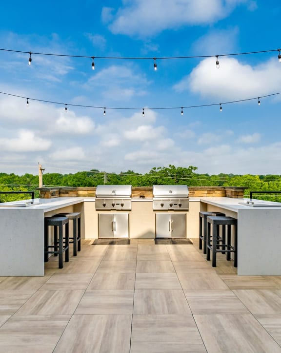 an outdoor kitchen with stainless steel appliances and bar stools