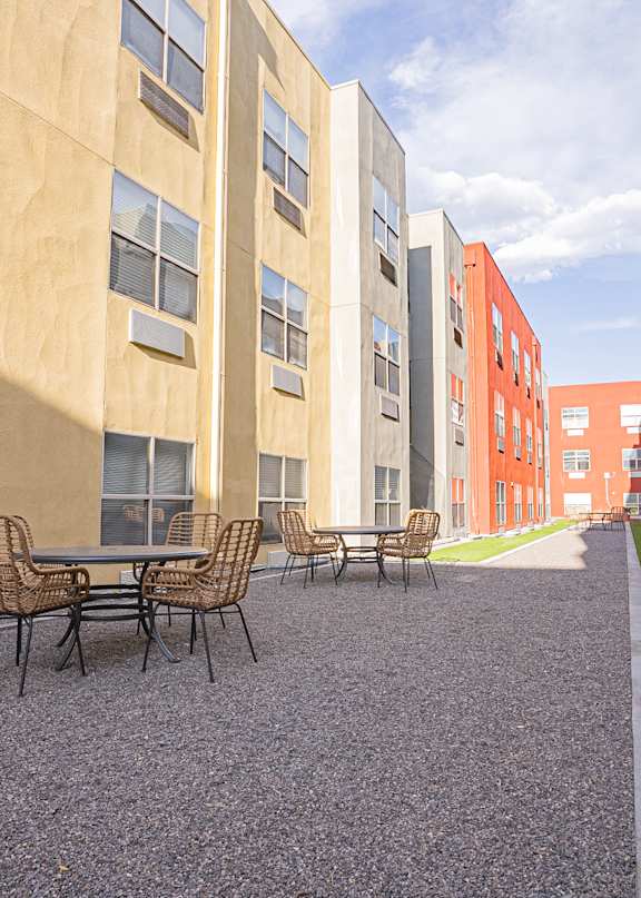 A patio with chairs and a table is surrounded by buildings. at ParcOne60, Reno, 89501